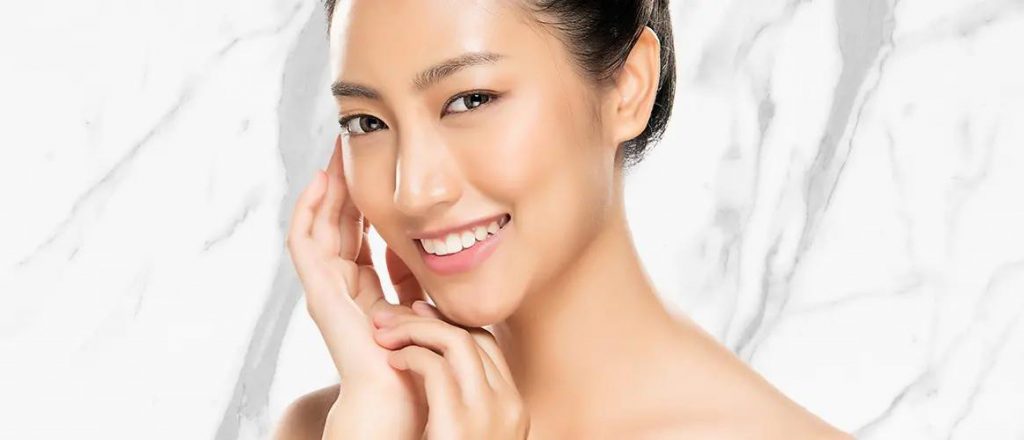 A beautiful woman is smiling after acne scarring treatment.